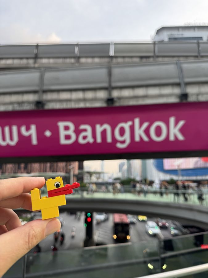 A duck held up in front of a Bangkok sign